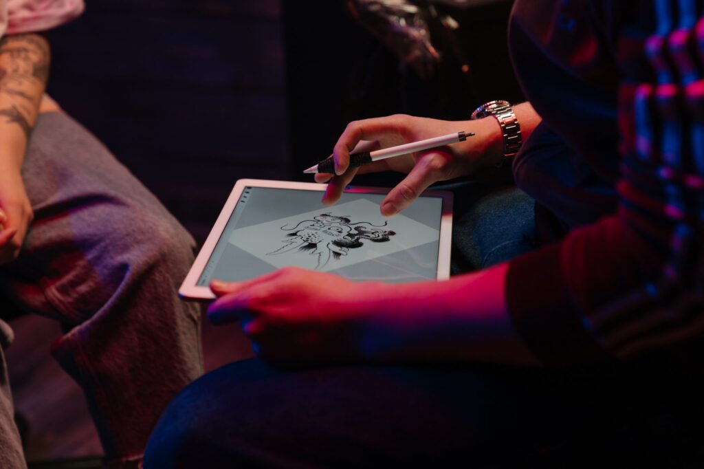 Artist drawing a custom tattoo design at a studio desk