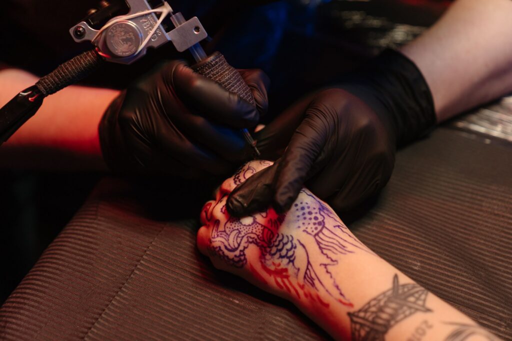 Tattoo artist applying ink during an active tattoo session with precision